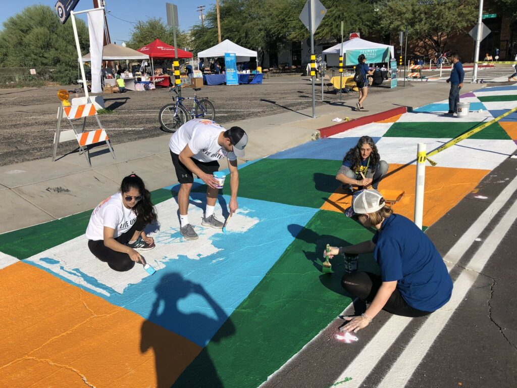 Tucson residents paint the street orange, green, blue, and white to draw attention to a bike lane in their Complete Streets demonstration project.